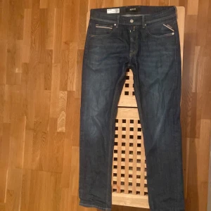Mörkblå jeansbyxor - Säljer ett par mörkblå jeansbyxor från Replay i mycket bra skick använt cirka 10-15 gånger och mycket varsamt . De har en slim passform och är perfekta för både vardag och fest. Klassisk femficksdesign. Märkeslappen i läder baktill ger en snygg detalj. Passar perfekt till höst- och vårsäsongen. Pris kan diskuteras vid snabb affär 