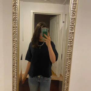 Svart t-shirt - Säljer en stilren blå t-shirt i normal passform. Perfekt för vardagsbruk och kan enkelt matchas med jeans eller kjol. T-shirten har korta ärmar och är gjord i ett mjukt material som känns skönt mot huden.