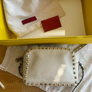 Valentino rockstud camera bag - I mycket bra skick!! Köpt på MyTheresa och allt på bilderna följer med💖 Väldigt ljus beige färg💞 (vid kanterna av lädret har färgen gått bort lite )