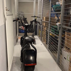 Svart elskoter med 1000W motor - Säljer min fatbike med en kraftfull 1000W borstlös navmotor och ett 60V 12Ah lithiumbatteri. Maxhastighet 30-35 km/h. Räckvidd 25-30 km i låg växel. Bakdäcket har punktering, men jag har ett extra däck som kan bytas ut. Kontakta mig vid intresse!