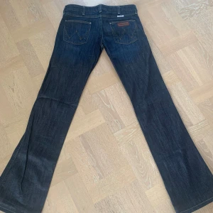 Lågmidjade bootcut Wrangler jeans - As snygga lågmidjade bootcut Wrangler jeans! Midjemått rakt över: 39cm. Innerbensläng: 78cm ❤️ om ni behöver mer information kontakta mig gärna privat ❤️❤️