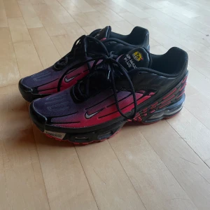 Nike Airmax Plus lll 3 TN tuned air - Skickas snabbt!!  Färgen är svart och röd som fadear in i Lila.  Har tyvärr gjort mig av med Boxen men skorna är endast använda ett fåtal gånger och är i nyskick Storlek 46 Skön sko som funkar till vardaglig användning eller löpning/ träning