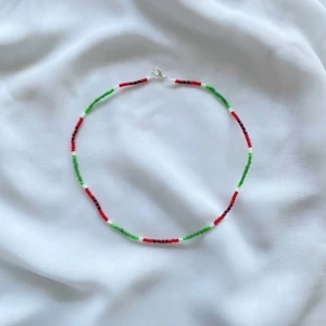 Färgglatt pärlhalsband(styck pris) - Säljer ett supercoolt halsband med små pärlor i rött, grönt och vitt. Perfekt för att liva upp vilken outfit som helst! Det har en enkel låsning och är lätt att bära. Passar både till vardags och festliga tillfällen.