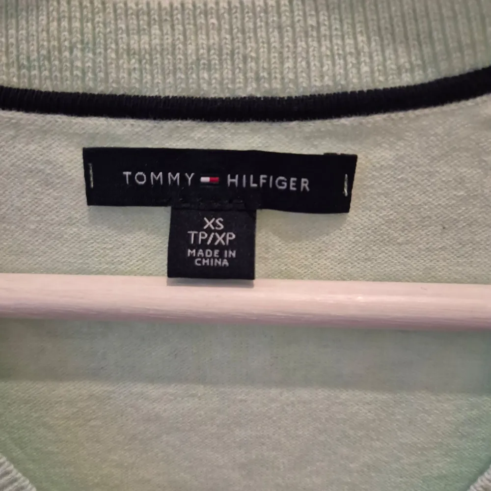 Tröja från Tommy Hilfiger. Mintgrön färg. Nyskick, aldrig använd. V-ringad form. Mjuk och skön material, väldigt bekväm. Märke på höger sida. Storlek XS. 65% bomull, 35% nylon. Axelbredd 36 cm, längd 63 cm.. Tröjor & Koftor.