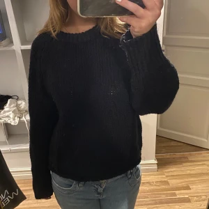Svart stickad tröja - Säljer en mysig svart stickad tröja. Den är perfekt för kyliga dagar och har långa ärmar. Tröjan är i bra skick och passar till både jeans och kjol. Perfekt för höst och vinter!