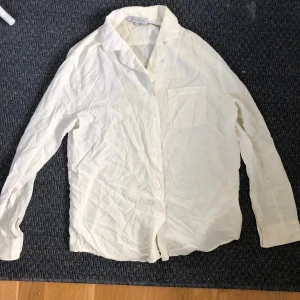 Vit skjorta från Lou in Love - Säljer en stilren vit skjorta från Lou in Love i storlek M. Skjortan har långa ärmar och knappar framtill. Perfekt för både vardag och festliga tillfällen! 