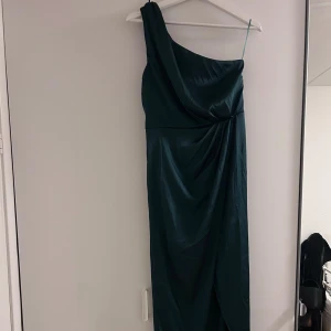 Klänning - Säljer denna fina enärmade klänning, har slits  