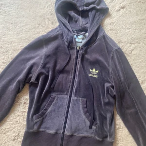 Adidas tröja - Lila Adidas tröja med guld detaljer. Den är sliten längst ner på armen men annars är den i bra skick! Köparen står för frakt! Tvättar tröjan innan jag skickar