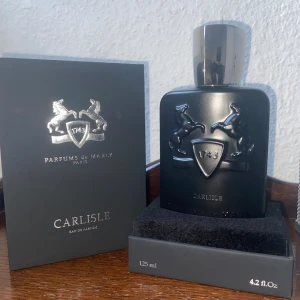 Carlisle Eau de Parfum från Parfums de Marly - Säljer en lyxig flaska av Carlisle Eau de Parfum från Parfums de Marly. Flaskan är elegant svart med en stilren design och har en kapacitet på 125 ml. Den har en sofistikerad doft som passar perfekt för speciella tillfällen. Tillverkad i Frankrike och innehåller 81% volym alkohol.