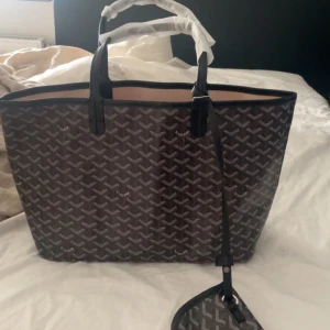 Goyard väska - En jättefin svart Goyard väska som är perfekt som skolväska. Det är oanvänd därav sitter plasten på banden fortfarande kvar. Lappen är också kvar. Skriv från frågor och funderingar💕