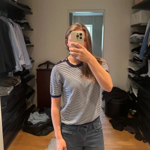 Randig bomullstyg-shirt - Säljer denna tröja med knappar på axlarna då den används för lite. Den är super mjuk och passar perfekt för vardagligt bruk tillsammans med t.ex jeans eller shorts.