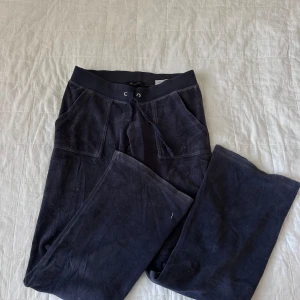 Svarta mjukisbyxor från Juicy Couture - Säljer ett par mörkblåa mjukisbyxor från Juicy Couture i storlek XS. Byxorna har en bekväm passform med resår och snörning i midjan. passar även S