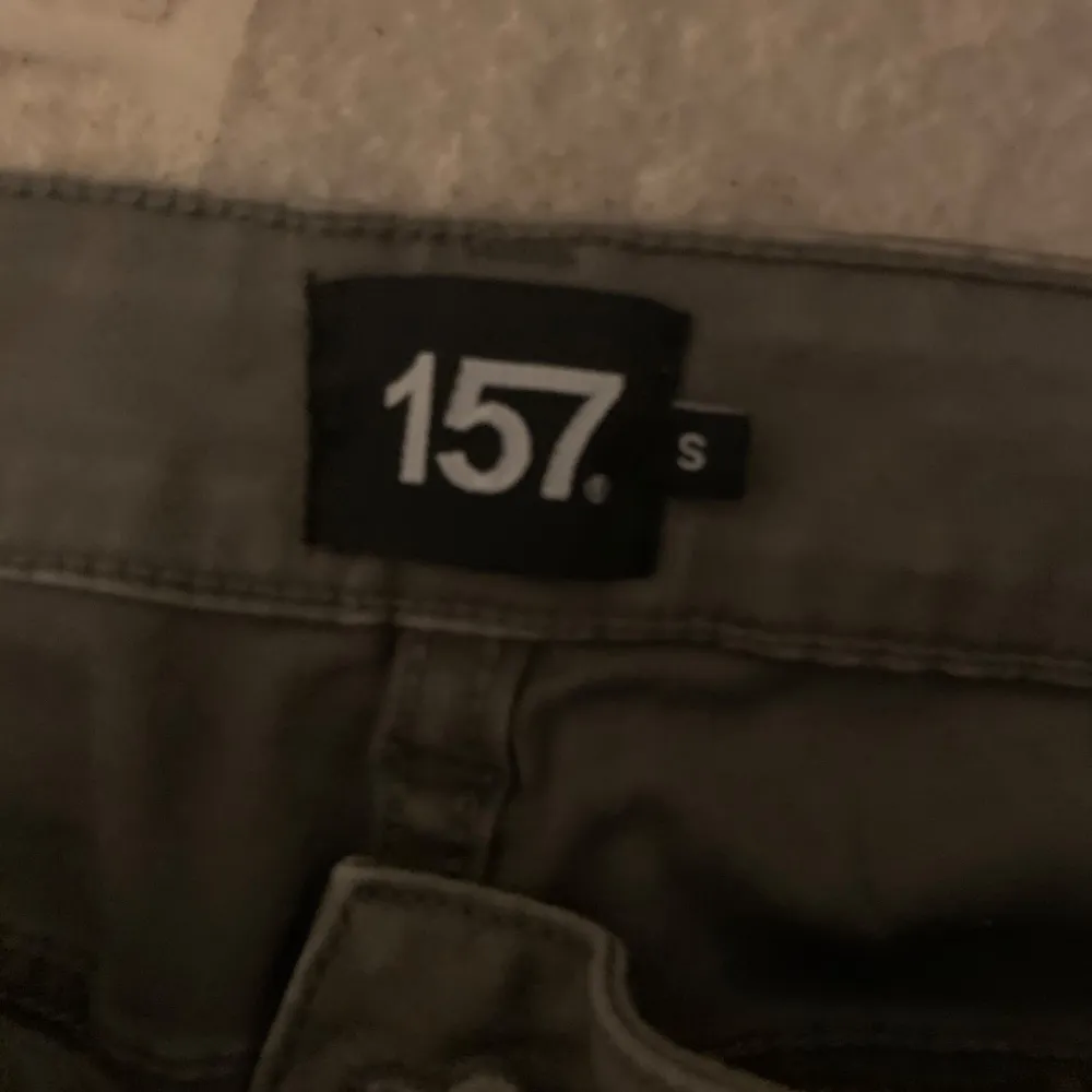 Säljer ett par gröna cargobyxor från 157. Byxorna har flera praktiska fickor och en bekväm passform med dragsko i midjan. Perfekta för en avslappnad stil.. Farkut & Housut.