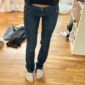 Låg midjade mörkblå jeans med broderade bakfickor - Snygga mörkblå disel jeans med broderade detaljer på bakfickorna. De har en låg midja och en straight passform som sitter perfekt. 