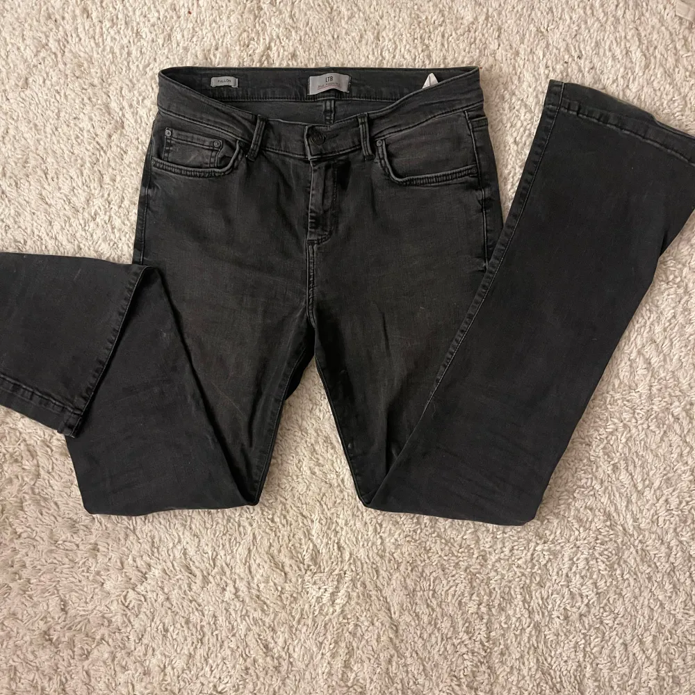 Snygga svarta jeans från LTB med klassisk femficksdesign och knappgylf. Perfekta för en stilren look. Märkesdetalj på baksidan av midjan. Modellen är Fallon och storlek 29-32! Midjemått : 39 cm innerbenslängd:80cm fotvidd :23cm Hela benet: 106 cm midjehöjd: 25 cm . Farkut & Housut.