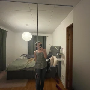 Svartvit blommig linne - Säljer ett svartvitt linne med blommigt mönster. Linnet har smala axelband och en luftig passform, perfekt för varma dagar. Passar bra till jeans eller shorts för en avslappnad stil.