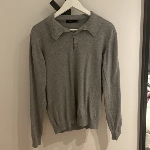 Grå tröja med krage från Matinique - Säljer en stilren grå tröja från Matinique i storlek XS. Tröjan har en klassisk krage och knappar framtill, perfekt för en avslappnad men ändå uppklädd look. Som ny. Pris går att diskuteras. 