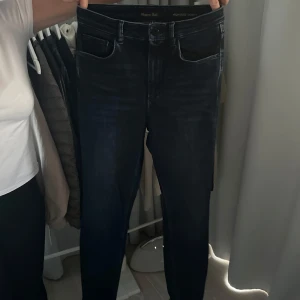 Mörkblå skinny jeans från Massimo Dutti - Snygga mörkblå skinny jeans från Massimo Dutti med hög midja. Perfekta för en stilren look. Klassisk femficksdesign och knappgylf. Tillverkade i ett stretchigt material för extra komfort. Storleken är 38 alltså M