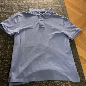 Ljusblå pikétröja från Ralph Lauren - Säljer en tvärfet ljusblå piké från Ralph lauren. Den ar bra nu till sommarn och har inte en enda defekt. Om du har några frågor skriv t mig och jag kan gå ner i pris vid snabb affär.