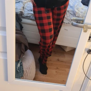 Röda och svarta rutiga byxor - Snygga och bekväma byxor i röd och svart rutig design. Perfekta för en avslappnad stil med elastisk midja för extra komfort. Passar bra till en enkel topp eller hoodie. Super stretchigt material så passar även storlek M. 