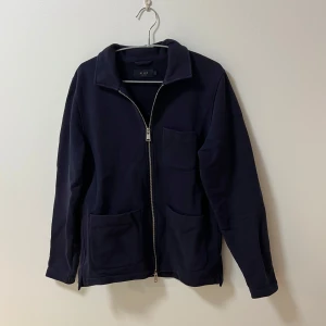 Riley kofta - Säljer en stilren mörkblå kofta från Riley med dragkedja framtill. Koftan är i jättefint skick och har inga defekter.