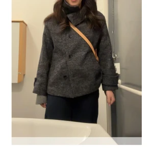 Grå ullkappa från Zara - Snygg grå kappa i ull från Zara med en stilren design. Jackan har en hög krage och knappar framtill. Perfekt för kyliga dagar med en bekväm passform😊. Köpt för ca 1 månad sedan men endast använd två gånger! Säljer pga den ej kommer till användning. Helt slutsåld online!!(färgen är grå/blå)👏🏻❤️