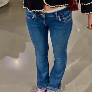 Lågmidjade jeans - Snygga blå jeans med en tight passform och låg midja. Perfekta för en avslappnad stil. De har klassiska fem fickor och en dragkedja framtill. Uppsprättade nertill och omsydda till mer lågmidjade 