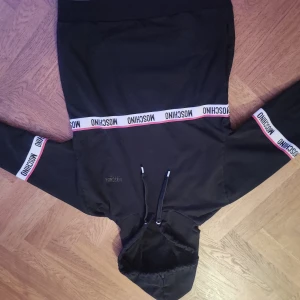 Moschino hoodie - Snygg svart hoodie från Moschino med vita och röda detaljer. Säljer för jag andvänder inte den längre pris kan diskuteras. Äkta moschino 