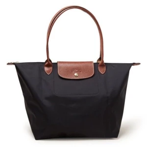 Svart longchamp väska L - Jättesöt äkta väska från longchamp! Den är helt utan defekter förutom att guldknappen har blivit jättelite blekare än från början, men det är inget man tänker på alls. Den är i så gott som helt oanvänt skick. Det får plats med en dator så den fungerar perfekt som skolväska! Nypris är 1730kr och mitt pris är 1200kr