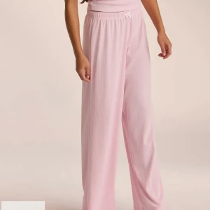 Byxor från Lounge - Säljer ett par rosa byxor från Lounge Underweae. Kan användas som pyjamasbyxor eller lounge byxor. Byxorna är endast använda en gång men har ett litet hål i sig vid sömnen vid rumpan. Detta går att laga lätt och syns knappt då byxorna har en loose passform.