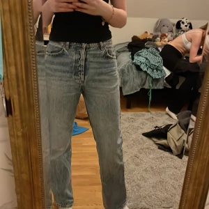 Blå jeans från Zara - Säljer ett par snygga blå jeans från Zara i storlek S. De har en klassisk femficksdesign och knappar i gylfen. Perfekta för en avslappnad stil.