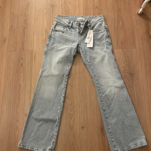 Ljusblå jeans med bootcut - Snygga ljusblå jeans med bootcut-stil och klassisk femficksdesign. De har en låg midja och är perfekta för en avslappnad look. Jeansen har en dragkedja och knapp framtill. Passar 36-38 prislappen sitter på byxorna så ej använda ny pris 500 mitt pris 350🥰