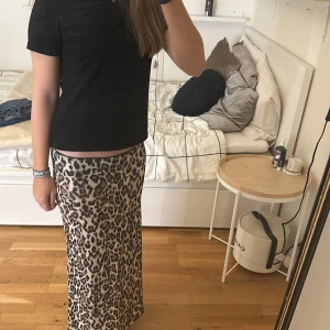 Leopardmönstrad långkjol - Snygg leopardmönstrad långkjol i en skön och stilren design. Kjolen har en normal passform och är perfekt för att ge en trendig touch till din outfit. Den är lätt att matcha med olika toppar och accessoarer.