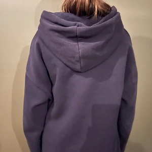 Hoodie - Säljer en mörkblå hoodie med texten 'MA CHÉRIE' i glittriga detaljer på framsidan. Tröjan har en bekväm passform och en stor huva. Perfekt för en avslappnad stil. Den är lite urtvättad men annars är det i ett bra skick.