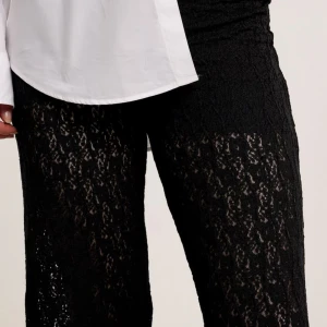 Svarta spetsbyxor - Snygga svarta byxor i spetsmaterial med en elegant och genomskinlig look. Byxorna har en rak passform och är perfekta för att ge en stilfull touch till din outfit.
