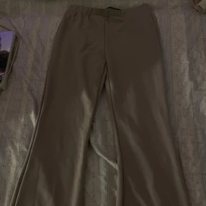 Beige byxor - Snygga beige byxor med en avslappnad passform. Perfekta för en stilren look. De har en elastisk midja för extra komfort.