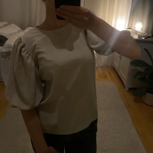 Beige blus med puffärmar - Säljer en stilren beige blus med puffiga kortärmar. Perfekt för en chic och elegant look. Blusen har en rund halsringning och är tillverkad i ett mjukt material. Typ aldrig använd då den inte passar min stil. Sitter superfint på en person som brukar vara strl XS. Vet ej vart den är ifrån tyvärr!!🙏🏼 hör av dig om du undrar något eller vill diskutera pris!❤️🫶🏻