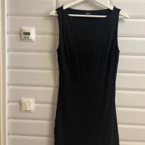 Svart klänning från Gina Tricot storlek:M  - Snygg svart klänning från Gina Tricot i en klassisk design. Klänningen är ärmlös och har en smickrande passform som passar perfekt för olika tillfällen. Enkelt och stilrent plagg som är lätt att matcha med accessoarer. Aldrig använd. Säljer för 175 kronor. 