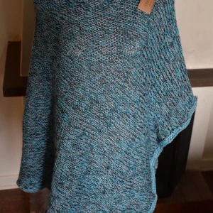 Blå stickad poncho från JANMIKAEL - Säljer en snygg blå stickad poncho från JANMIKAEL . Perfekt för att hålla sig varm och stilren under kyliga dagar. Den har en lös passform och är lätt att matcha med olika outfits. Ett måste för garderoben! 💙