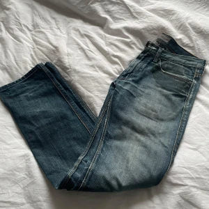 Blå jeans från Acne - Snygga blå jeans från Acne i klassisk stil. De har en rak passform och är tillverkade av 100% bomull. Perfekta för en avslappnad look med en touch av stil. Unik tvätt.