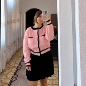 Rosa kofta med guld knappt - Säljer en superfin rosa kofta med svarta kanter och knappar framtill. Koftan är i ett mjukt stickat material och har en klassisk look, gossip girl vibe. Passar perfekt till höst och vår!💋❤️storlek S, i nyskick. Skriv vid frågor 🥰