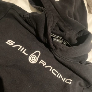 Sail racing hoodie  - Svart sail racing tröja med luva i storlek 140. Använd och är för liten nu på sonen 