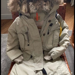parajumper jacka -  köpt för 10 000parajumper vinterjacka, beige, knappt använd, Fick i present och vill ej ha kvar. håller en varm om vintern. Luvan går att ta bort