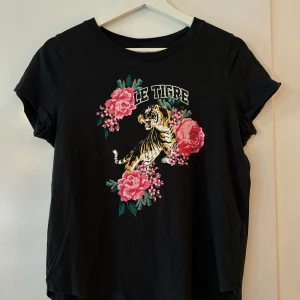 T-shirt från ginatricot  - Svart T-shirt med tryck från Gina Tricot. Aldrig använd men utan prislapp. Normal i storleken, passar S/M.