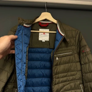 Olivgrön märkesjacka från Peuterey - Säljer en snygg olivgrön quiltad jacka från Peuterey i storlek S. Jackan har en stilren design med dragkedja och flera praktiska fickor. Perfekt för höst och vår, med en cool blå insida som ger extra stilpoäng. Passar både till vardags och lite finare tillfällen. 🧥✨Sparsamt använd i bra skick! 