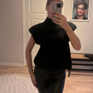 Stickad väst - Stickad väst med axelvaddar. Använd 1 gång. Stl S. 