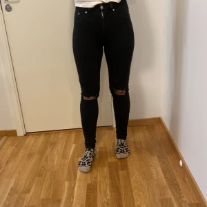 Svarta jeans från 157 - Säljer ett par svarta skinny jeans från 157. De är högmidjade och har snygga slitningar på knäna. Perfekta för en casual look eller en utekväll. De är i bra skick och passar till det mesta i garderoben. Skicka ett meddelande vid intresse!