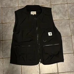 Carhartt väst - Carhartt väst. Nypris 1700kr. Köpt våren 2020. Använd fåtal gånger. Storlek L. Många fickor vilket bidrar till en skate känsla. 