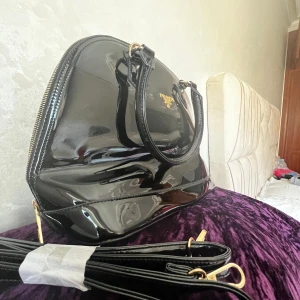 Svart Prada lackväska i toppskick - Säljer min svarta Prada Milano lackväska som är i perfekt skick!  kan ta halva priset också skriv gärna 🥰absolut INGA skado, och alla metalldetaljer är  nya. Väskan är riktigt snygg och passar perfekt till allt. Priset kan diskuteras såklart. 