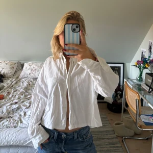 Vit croppad skjorta🤍 - Säljer en vit croppad skjorta med knappar framtill. Skjortan har en avslappnad och loose passform med långa ärmar. Perfekt för en stilren och casual look🤍